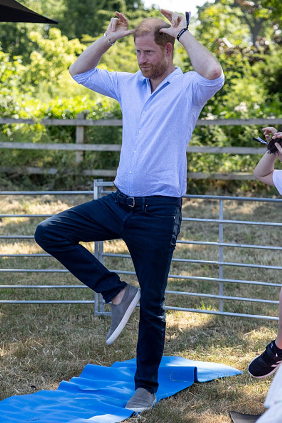 Konzentriert versucht sich Prinz Harry im Gleichgewicht auf einer Yoga-Matte.