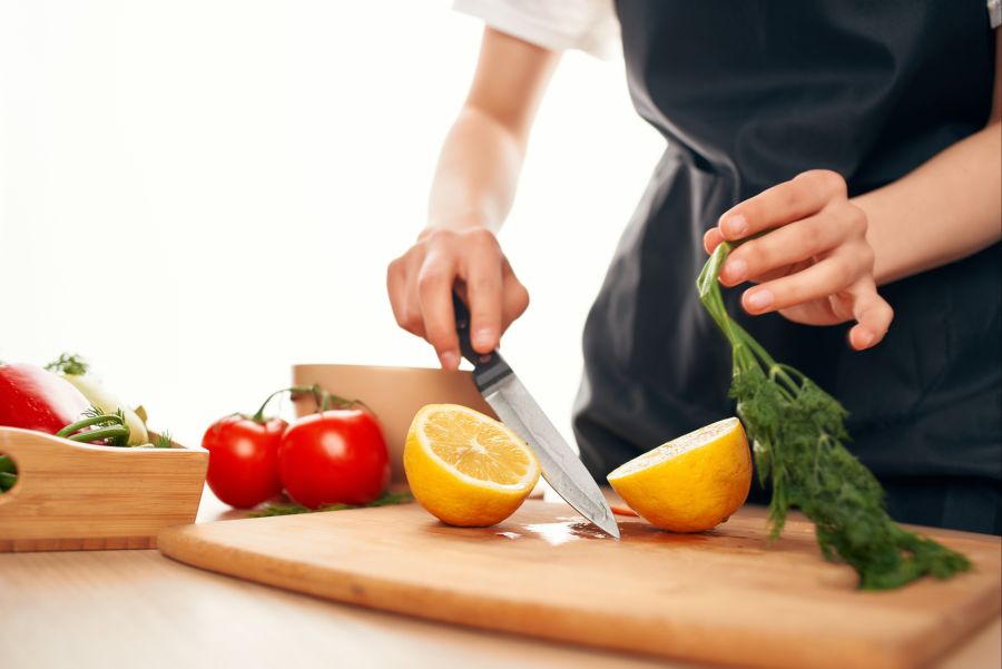 Person schneidet Obst und Gemüse