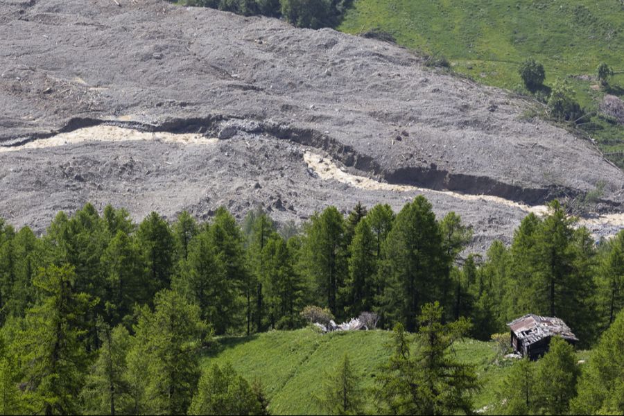 Wasser der Lonza strömt über Schlamm und Geröll, nachdem sich ein See bei den letzten Häusern von Blatten gebildet hat.