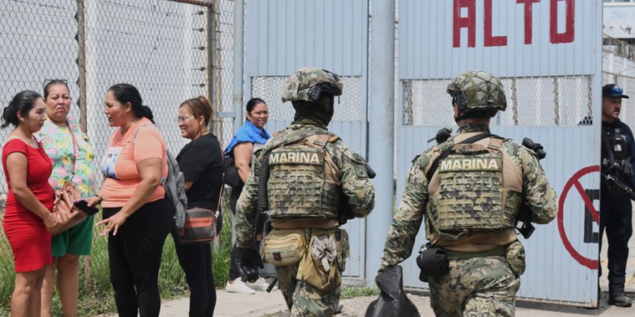 Angehörige von Häftlingen stehen während Auseinandersetzungen im El-Castillo-Gefängnis neben Offizieren der mexikanischen Marine. Foto: Fausto Camacho/AP/dpa