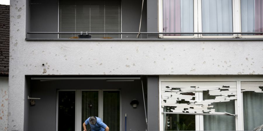 Eine Frau reinigt ihren Balkon nach dem heftigen Hagelgewitter am 28. August in Bülach. (Archivbild)