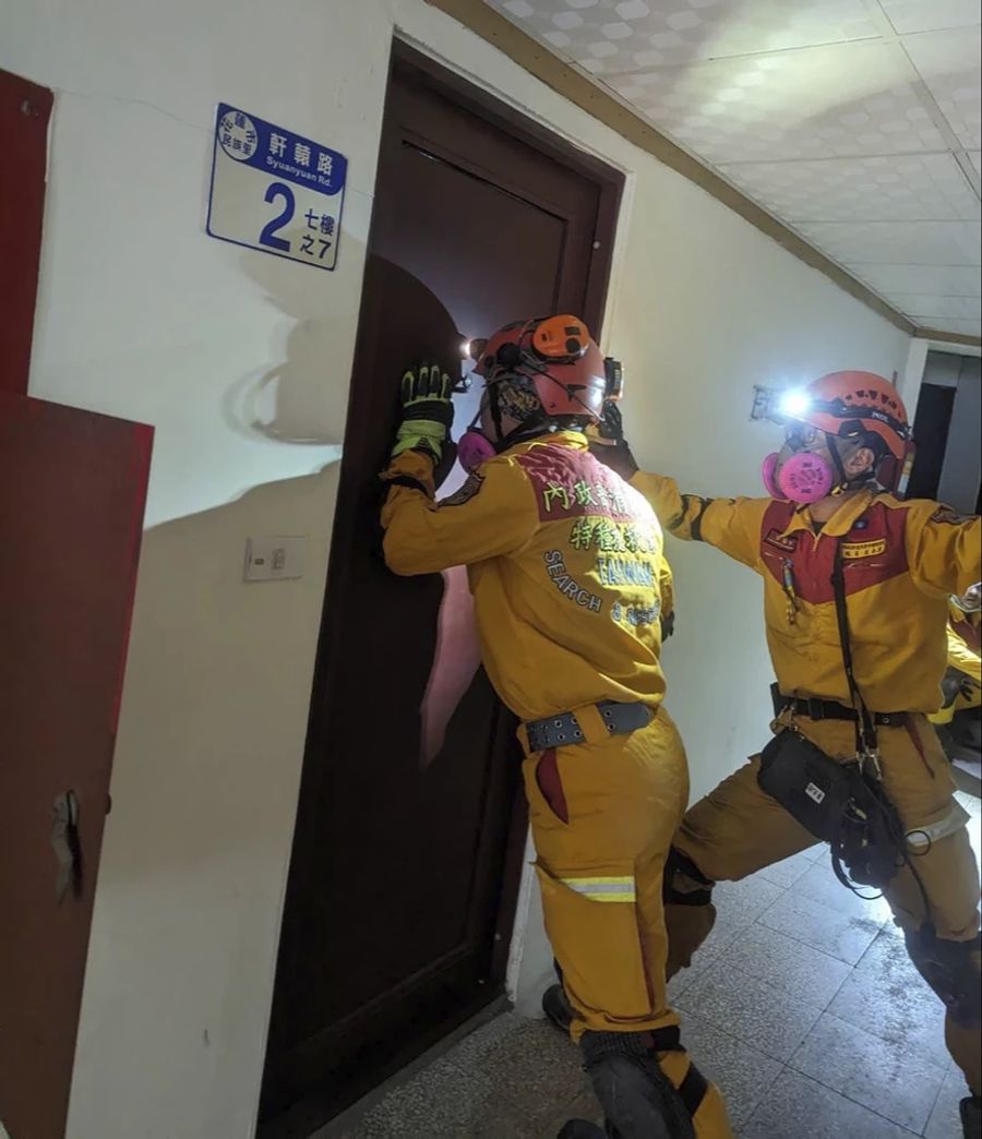 Rettungskräfte suchen nach eingeschlossenen Menschen in Häusern.