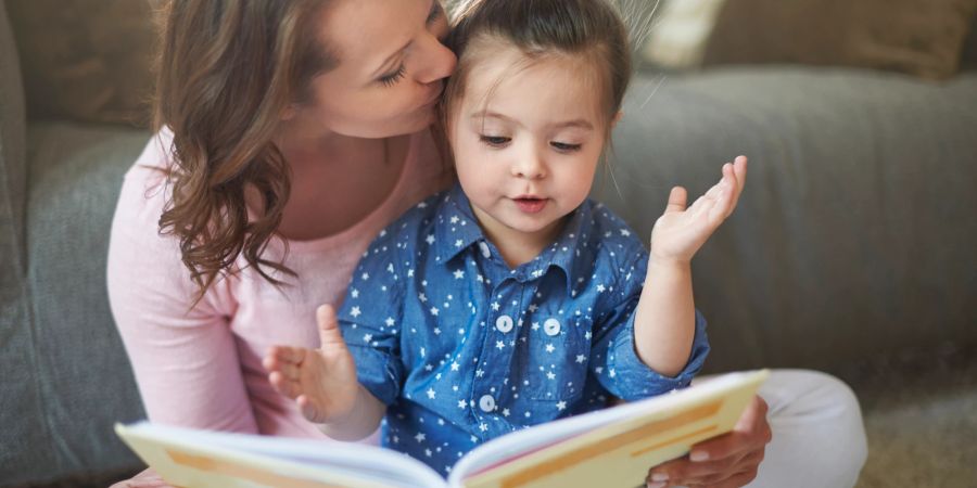 Mutter liest mit Tochter ein Buch