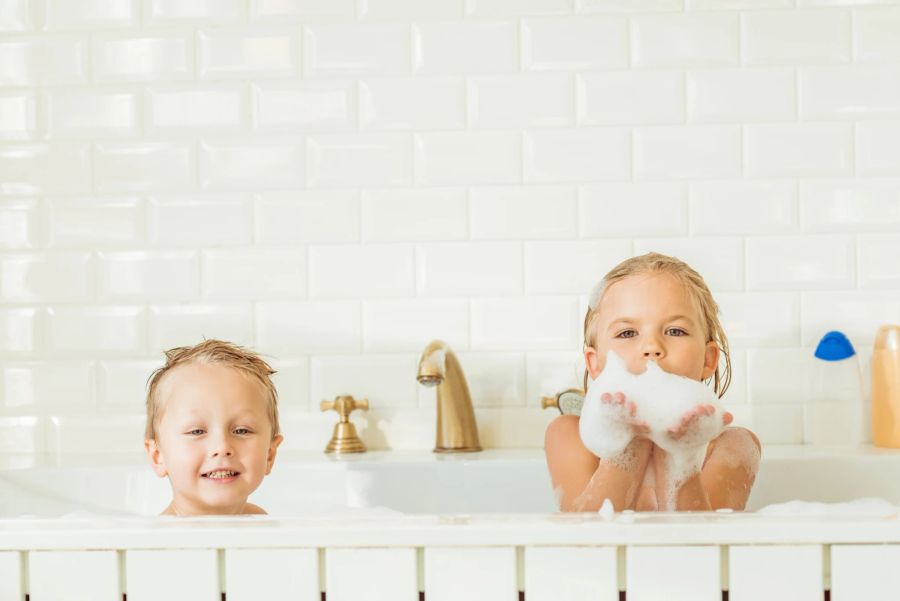 kinder spielen in der badewanne mit schaum