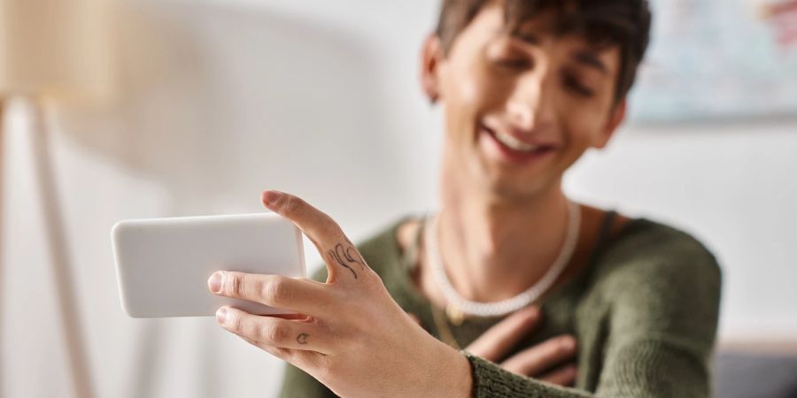 Junger Mann schaut auf sein Smartphone