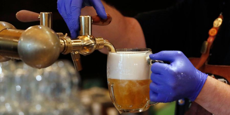 Ein Barkeeper zapft ein Bier auf einer Restaurant-Terrasse. (Symbolbild)