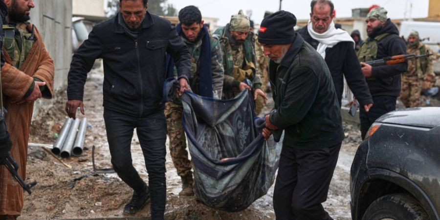 dpatopbilder - Syrische Regierungssoldaten und Einheimische tragen den Leichnam eines toten Zivilisten. Foto: Ghaith Alsayed/AP/dpa