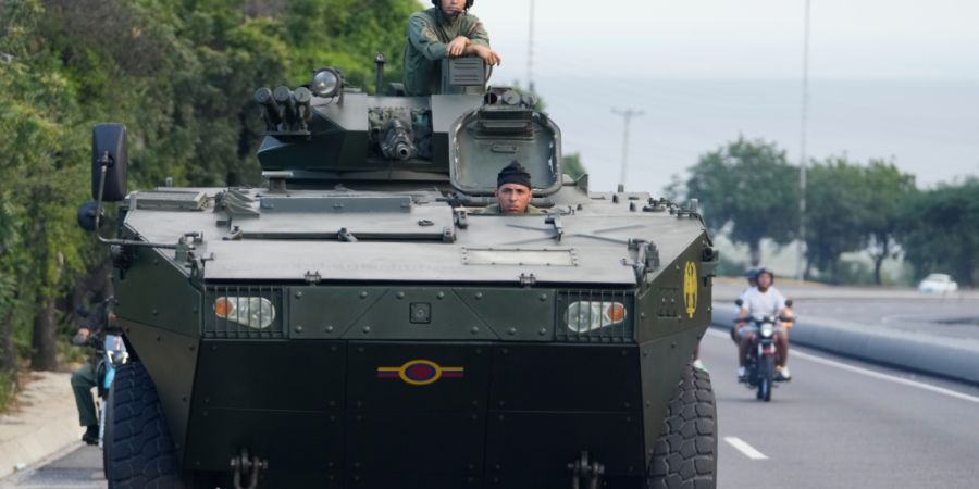 Ein Soldat steht auf einem gepanzerten Fahrzeug auf der Autobahn, die vom internationalen Flughafen nach Caracas führt. Foto: Matias Delacroix/AP/dpa