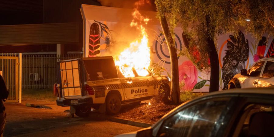 Ein Polizeifahrzeug brennt vor dem Krankenhaus in Alice Springs, wo ein Mann, der verdächtigt wird, ein fünfjähriges Mädchen getötet zu haben, unter Polizeibewachung steht. Foto: R...