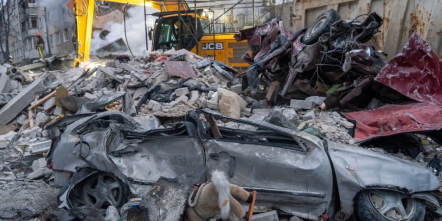 ARCHIV - Rettungskräfte räumen die Trümmer eines Wohnhauses nach einem russischen Raketenangriff in Charkiw. Foto: Andrii Marienko/AP/dpa (Archivbild)