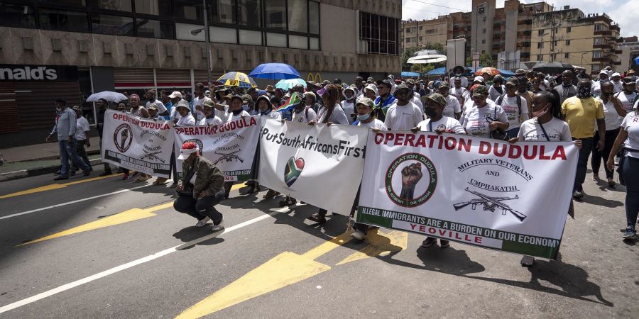 Mitglieder der "Operation Dudula" marschieren eine Strasse im Stadtteil Hillbrow entlang um mehreren Unternehmen in der Gegend Memoranden zu übergeben.