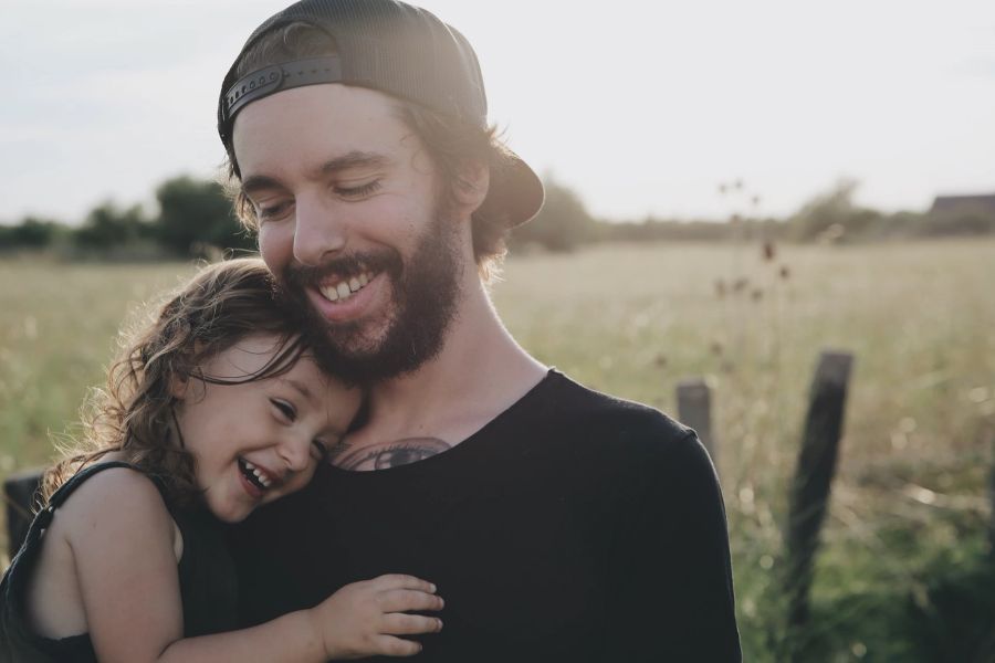 Mann Kind Tochter Feld kuscheln