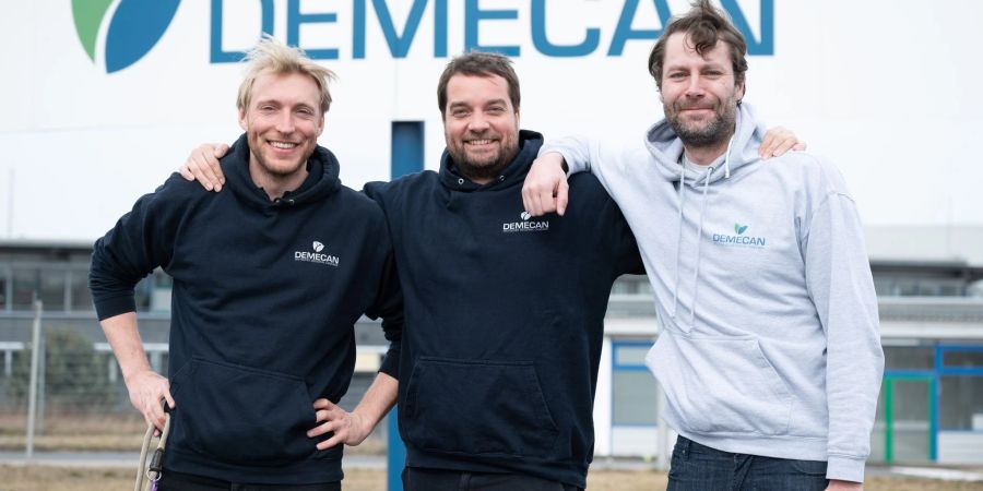 Geschäftsführer Constantin von der Groeben (l-r), Cornelius Maurer und Adrian Fischer stehen vor dem Demecan-Firmengelände.