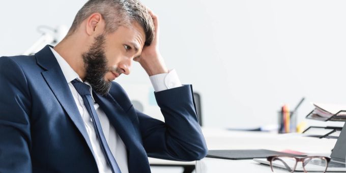 Wenn man dauerhaft nichts aus seiner Arbeit zieht, sollte man über einen Jobwechsel nachdenken. Mann frustriert die Arbeit