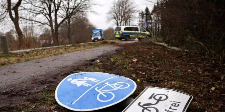 Ein umgeknicktes Verkehrsschild liegt auf dem Boden an der Unfallstelle in Neumünster. Foto: Christian Charisius/dpa