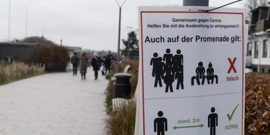 «Gemeinsam gegen Corona»: Ein Schild an einer Promenade weist darauf hin, dass der Abstand eingehalten werden muss. Foto: Frank Molter/dpa