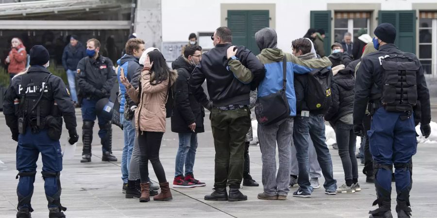 Ein kleines Grüppchen von Demonstranten wird bei einer Kundgebung gegen die Corona-Massnahmen von Polizisten beobachtet, am Samstag, 2. Januar 2021, auf dem Bundesplatz in Bern.