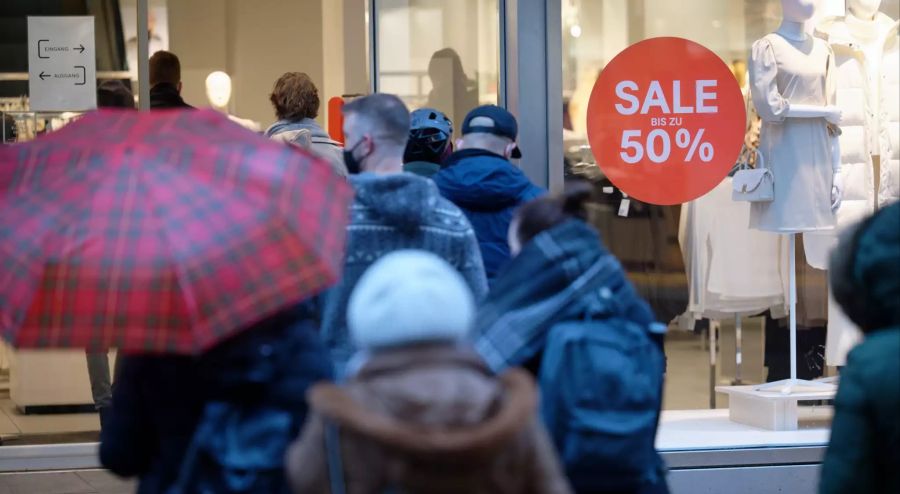 Kunden warten vor einem Bekleidungsgeschäft in Köln auf Einlass. Am letzten Tag vor dem Lockdown möchten viele noch ein Weihnachtsgeschenk kaufen.