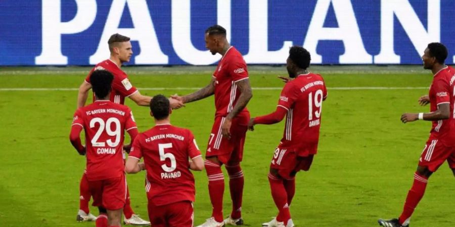 Bayerns Torschütze zum 1:0, Jerome Boateng (M), lässt sich von Assistgeber Joshua Kimmich gratulieren. Foto: Guenter Schiffmann/AFP Pool/dpa