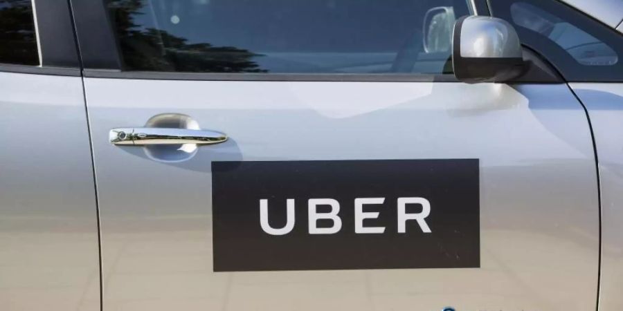 Das Firmenlogo von Uber klebt an einer Autotür in London. Foto: Laura Dale/PA Wire/dpa