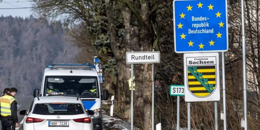 Deutsche Polizeibeamte kontrollieren ein Fahrzeug am tschechisch-deutschen Grenzübergang Petrovice/Bahratal im Erzgebirge. Foto: Ondøej Hájek/CTK/dpa