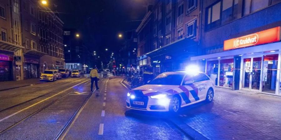 Ein Einsatzwagen in der Ferdinand Bolstraat in Amsterdam. Foto: Michel Van Bergen/ANP/dpa