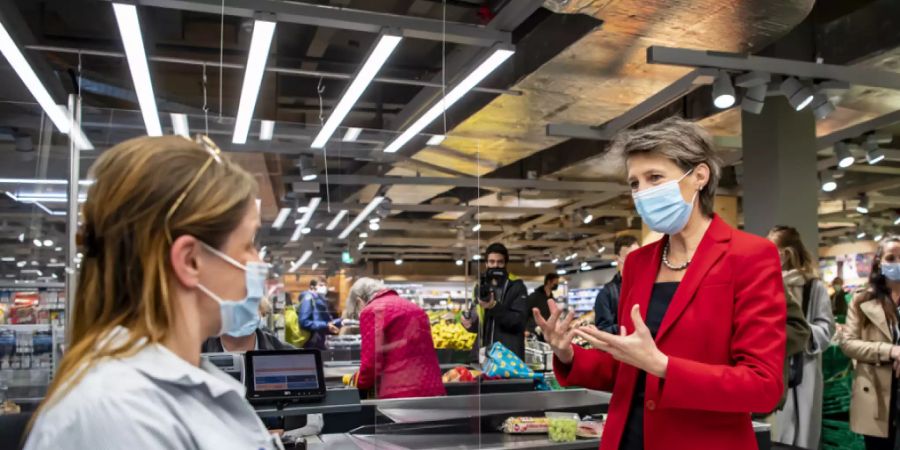 Bundesrätin Simonetta Sommaruga tauscht sich in Lausanne mit einer Verkäuferin aus.