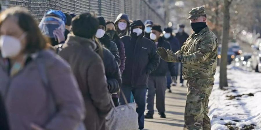 Menschen warten im New Yorker Stadtteil Queens vor einem Impfzentrum. Foto: Seth Wenig/AP/dpa