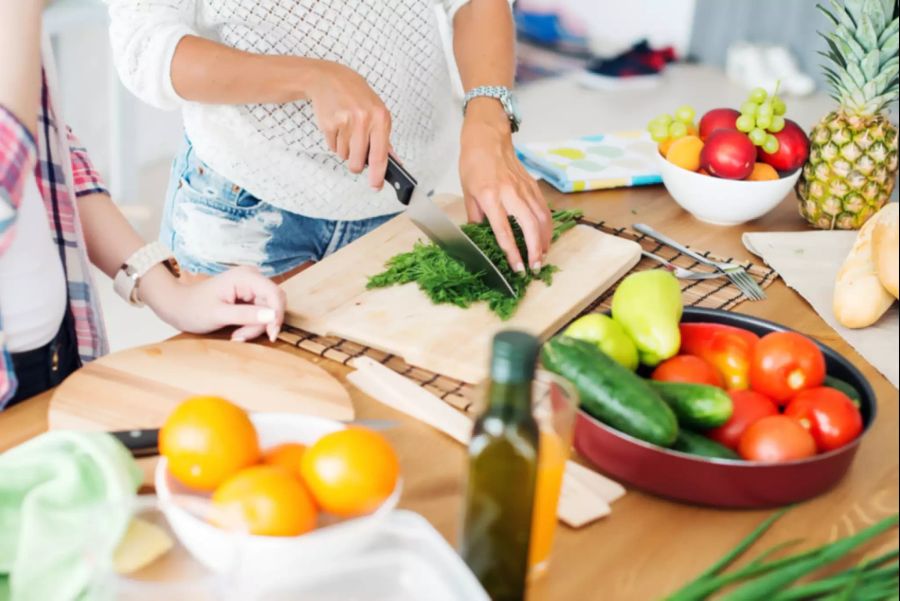 Frau schneidet Kräuter, kochen.