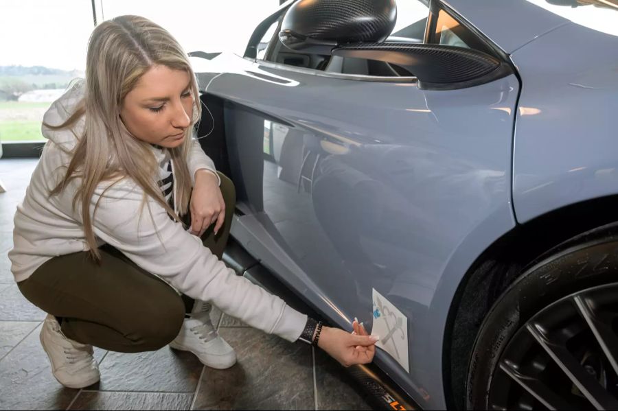 Michèle Uhlmann sucht die geeignete Stelle an einem McLaren für ein Logo.