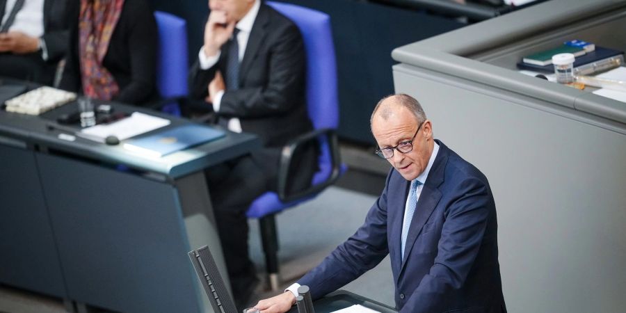 CDU-Chef Friedrich Merz spricht im Bundestag, dahinter sitzt Bundeskanzler Olaf Scholz (SPD).