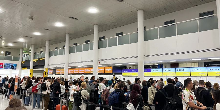 Passagiere in Warteschlangen am Flughafen Gatwick im South Terminal.