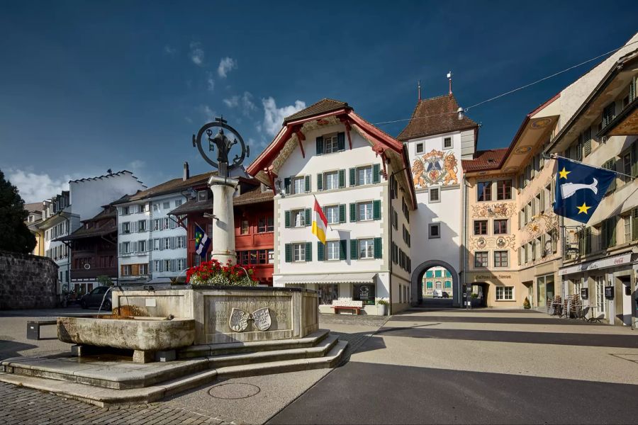 Der Obere Stadtbrunnen mit Blick auf das Obertor; im Vordergrund einer der drei siebeneckigen Brunnen, die mit ihren Bronzefiguren der Stadtheiligen Petrus und Paulus sowie der Muttergottes