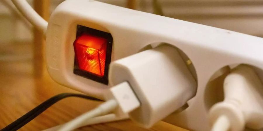 Stecker sind in einem Wohnzimmer in eine Steckdosenleiste gesteckt. Foto: Fernando Gutierrez-Juarez/dpa-Zentralbild/dpa