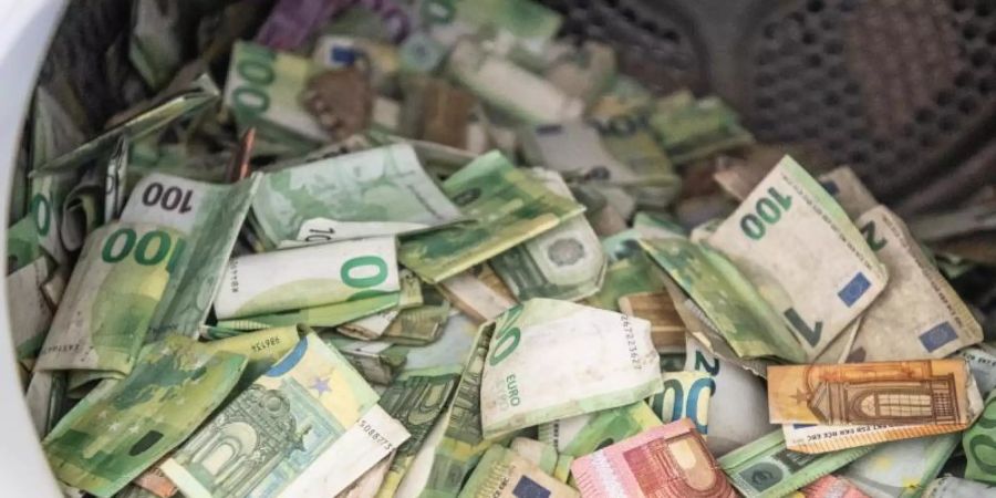 Bei der Flutkatastrophe beschädigte Euro-Banknoten werden bei der Bundesbank in Mainz in einem handelsüblichen Wäschetrockner getrocknet. Foto: Boris Roessler/dpa