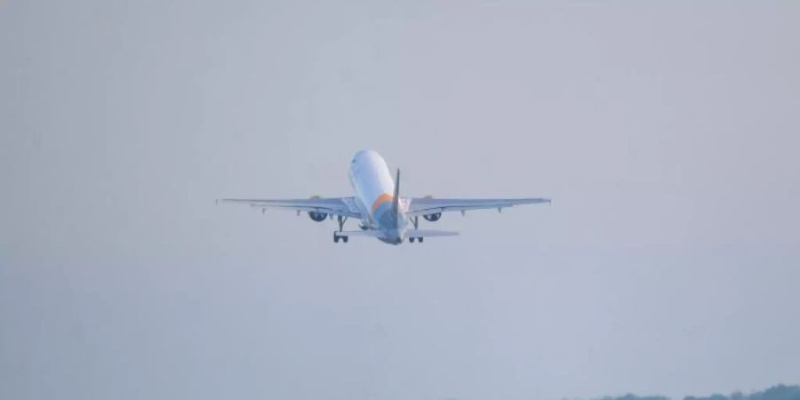 Ein Flugzeug hebt am frühen Morgen von der Startbahn ab. Foto: Jonas Walzberg/dpa