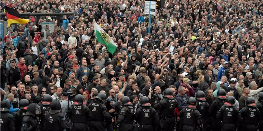 Polizisten bilden eine Absperrung, um das Aufeinandertreffen von den Tausenden rechten Demonstranten und kleineren, linken Gruppen in Chemnitz zu verhindern.