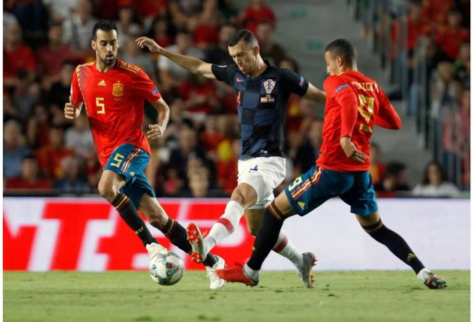 Kroatiens Ivan Perisic in Aktion um den Ball mit den Spaniern Sergio Busquets (l.) und Rodrigo Moreno. Kroatiens Ivan Perisic in Aktion um den Ball mit den Spaniern Sergio Busquets (l.) und Rodrigo Moreno.