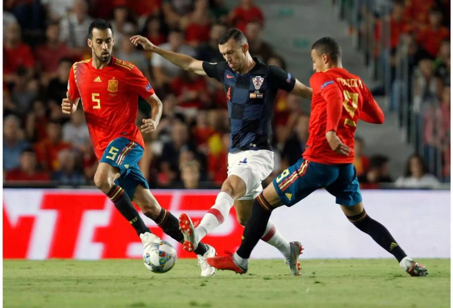 Kroatiens Ivan Perisic in Aktion um den Ball mit den Spaniern Sergio Busquets (l.) und Rodrigo Moreno.