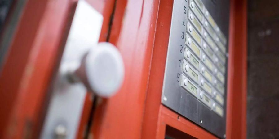 Klingelschilder hängen neben der Eingangstür eines Mehrfamilienhauses.