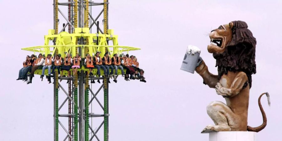 Besucher des Oktoberfestes sitzen in dem Fahrgeschäft «Freier Fall».