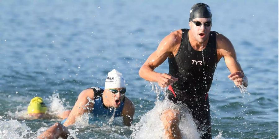 Die beiden Deutschen Jan Frodeno (r) und Patrick Lange (M) kommen bei der Ironman Europameisterschaft nach dem Schwimmen im Langener Waldsee aus dem Wasser.