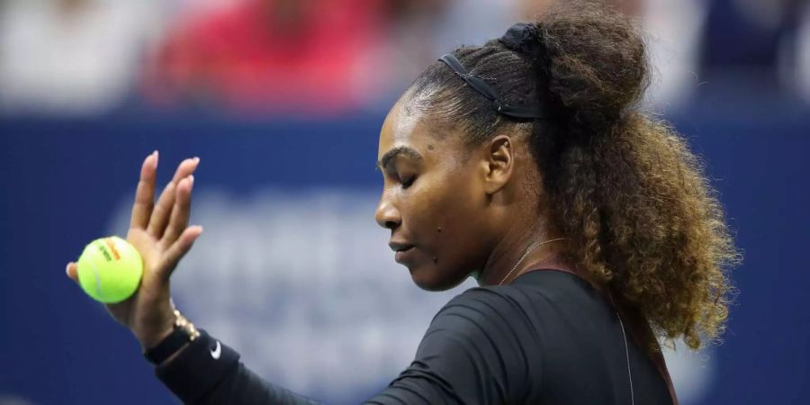 Serena Williams fängt den Ball mit der linken Hand.