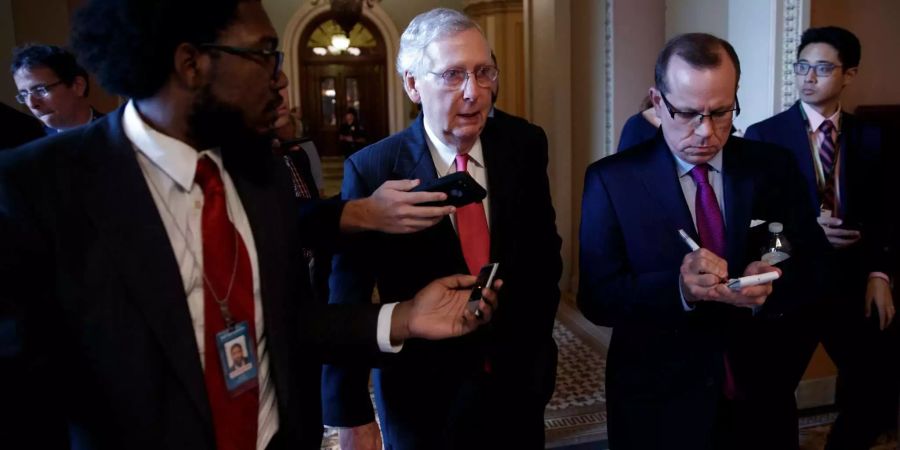 Mehrheitsführer Mitch McConnell (m.) beantwortet Fragen der Medien.