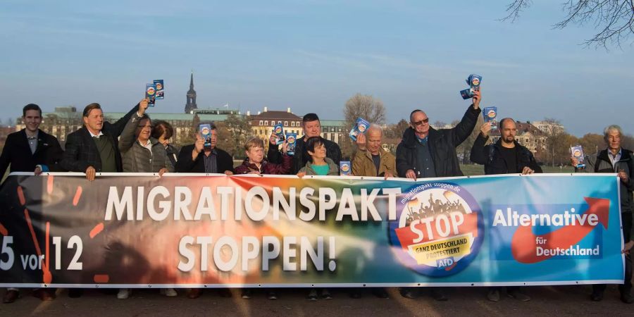 Mitglieder der Meissner AfD stehen während der Landtagssitzung vor dem Landtag in Dresden (D) und halten einen Banner mit der Aufschrift «Migrationspakt stoppen!».