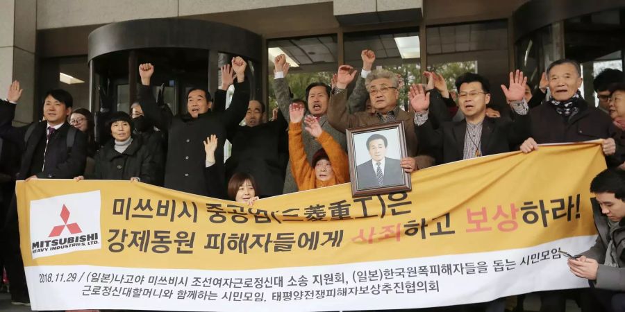 Die koreanischen Zwangsarbeiter und ihre Angehörigen jubeln nach dem Urteil in Seoul.