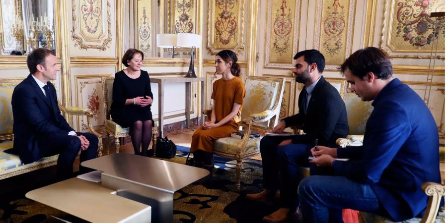 Friedensnobelpreisträgerin Nadia Murad Basee Taha (M) redet mit Frankreichs Präsident Emmanuel Macron (l) während eines Treffens im Élysée-Palast.