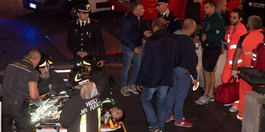 Rettungskräfte bringen einen Mann, der bei dem Einsturz einer Rolltreppe an der U-Bahnstation «Repubblica» verletzt wurde, in einen Krankenwagen.