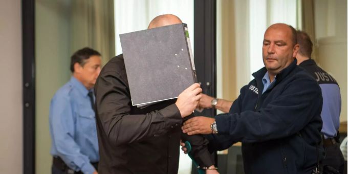 Der Angeklagte, der sein Gesicht hinter einem Aktenordner verbirgt, wird vor Beginn der Verhandlung von den Justizbeamten in den Gerichtssaal im Landgericht gebracht. Der Angeklagte, der sein Gesicht hinter einem Aktenordner verbirgt, wird vor Beginn der Verhandlung von den Justizbeamten in den Gerichtssaal im Landgericht gebracht.