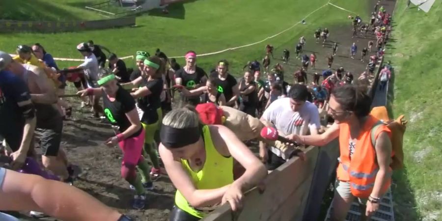 Da landet Simi Ammann normalerweise: Die Teilnehmer des Strongman Run laufen die Skisprungschanze hoch.